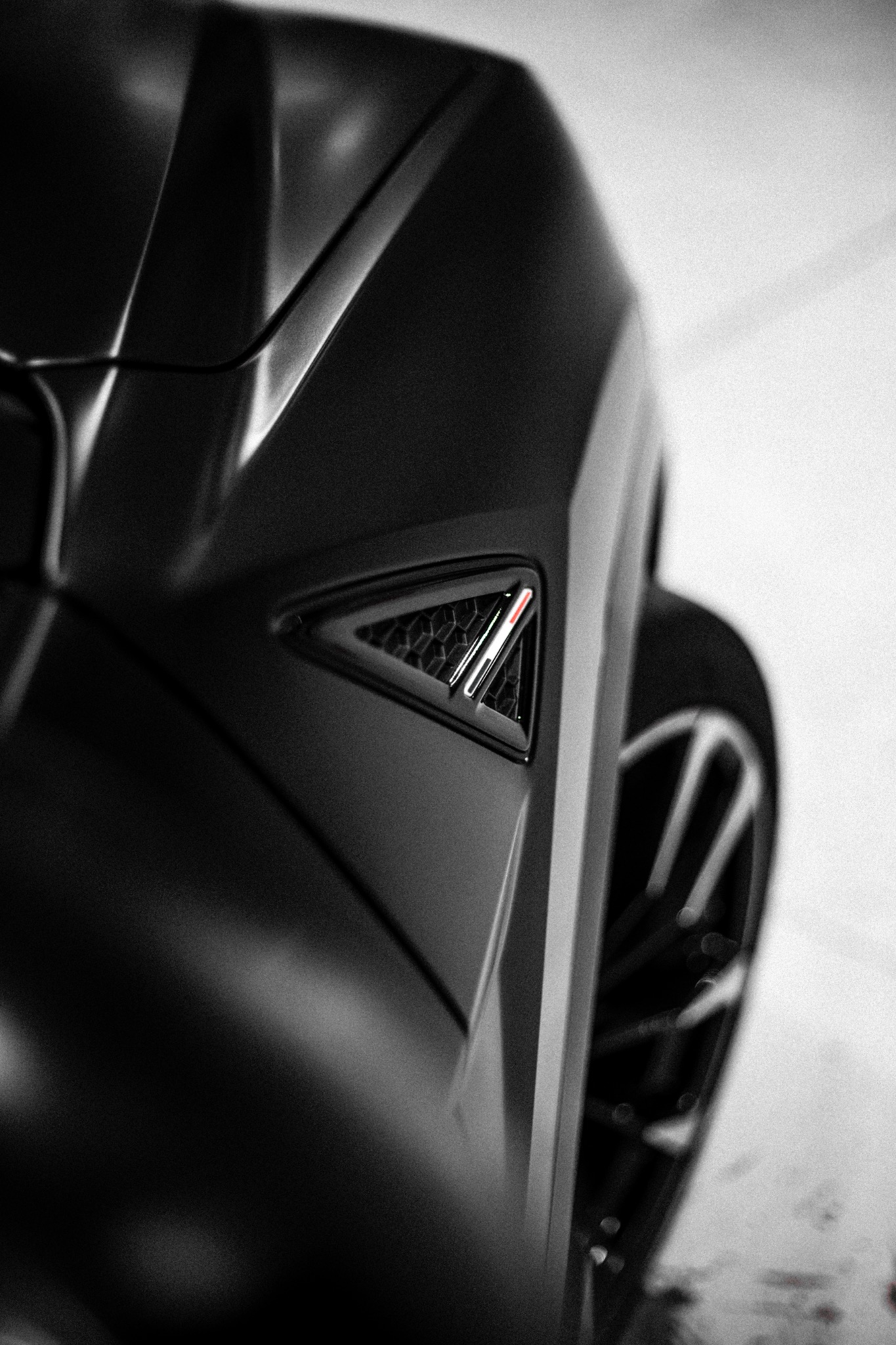Close-up of the Urus fender vent and Italian tricolor detail in matte black bodywork